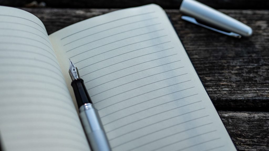 Un taccuino aperto con una penna, adatto per annotare appunti o idee