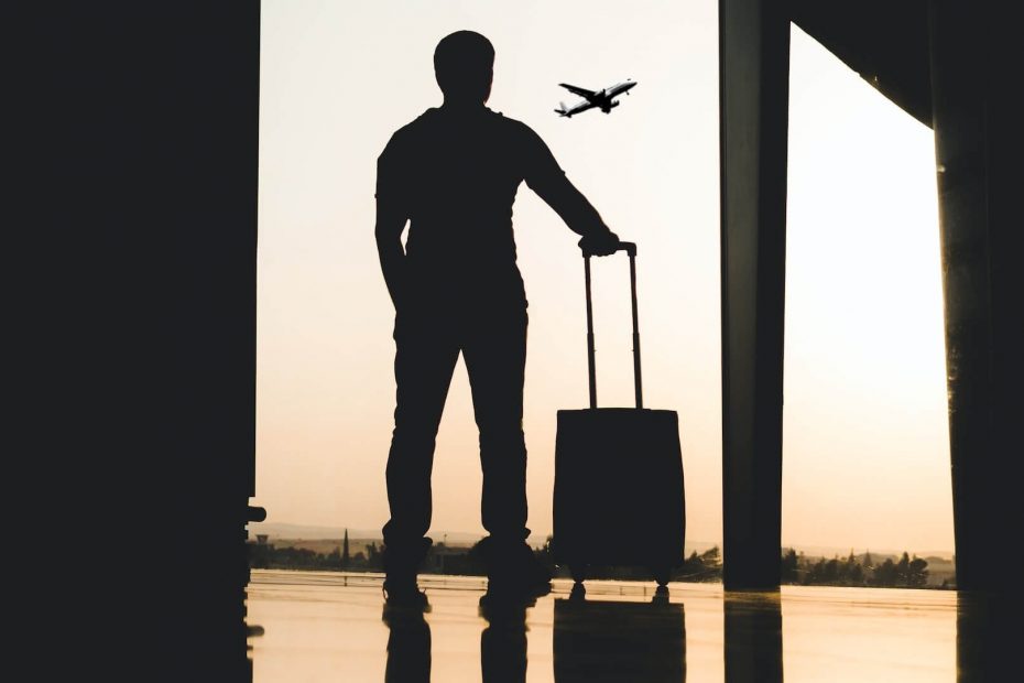 Un viaggiatore all'aeroporto, con una valigia in mano in preparazione di un viaggio